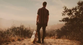 A guitar on a hillside at dusk